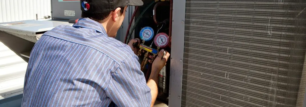 HVAC technician servicing a condenser unit in North Augusta